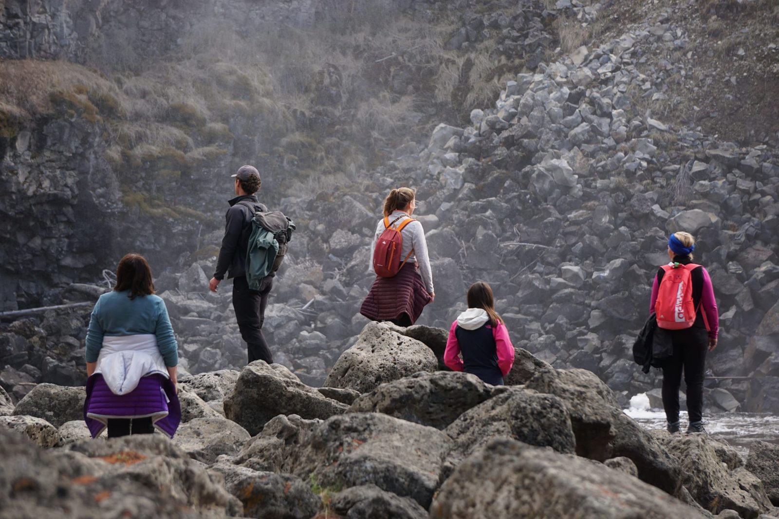 Groupe de marcheurs sur un terrain rocheux dans la brume
